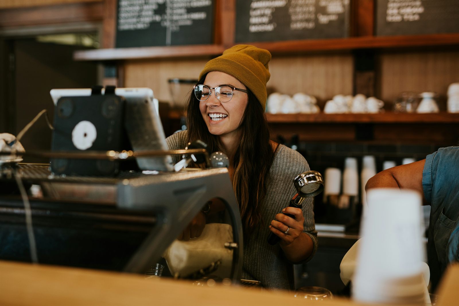 Barista z sitkiem ekspresu kolbowego za barem w kawiarni