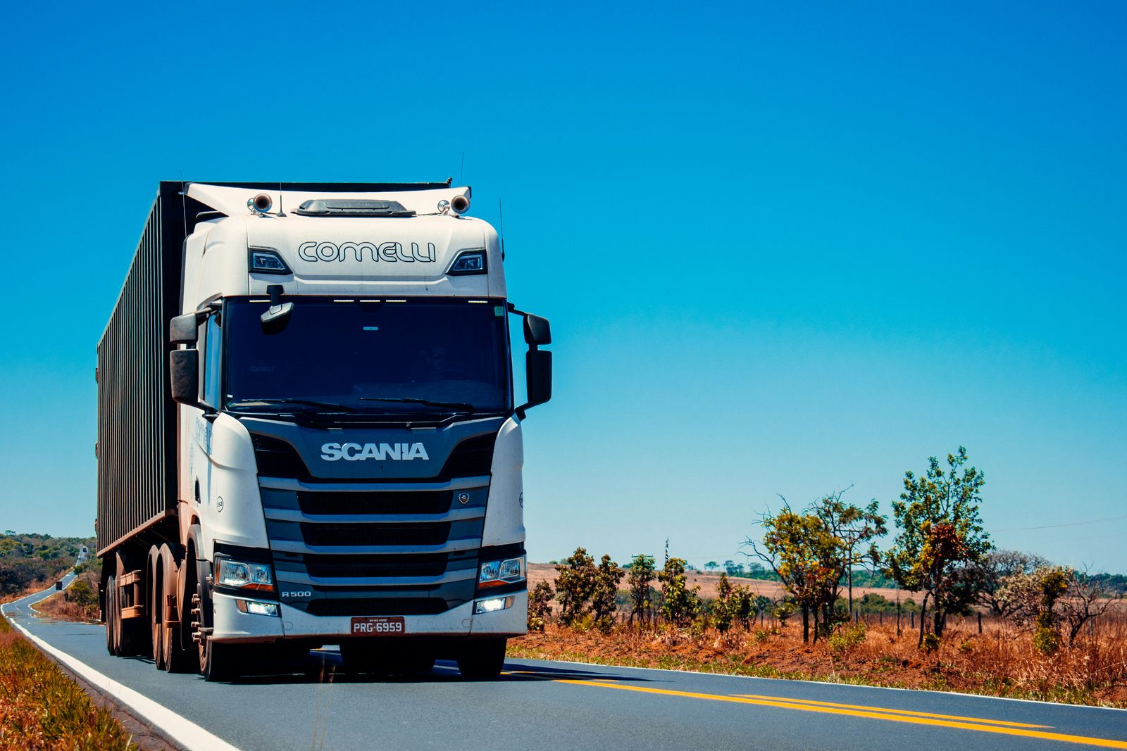 Ciągnik siodłowy Scania z naczepą na trasie w słoneczny dzień